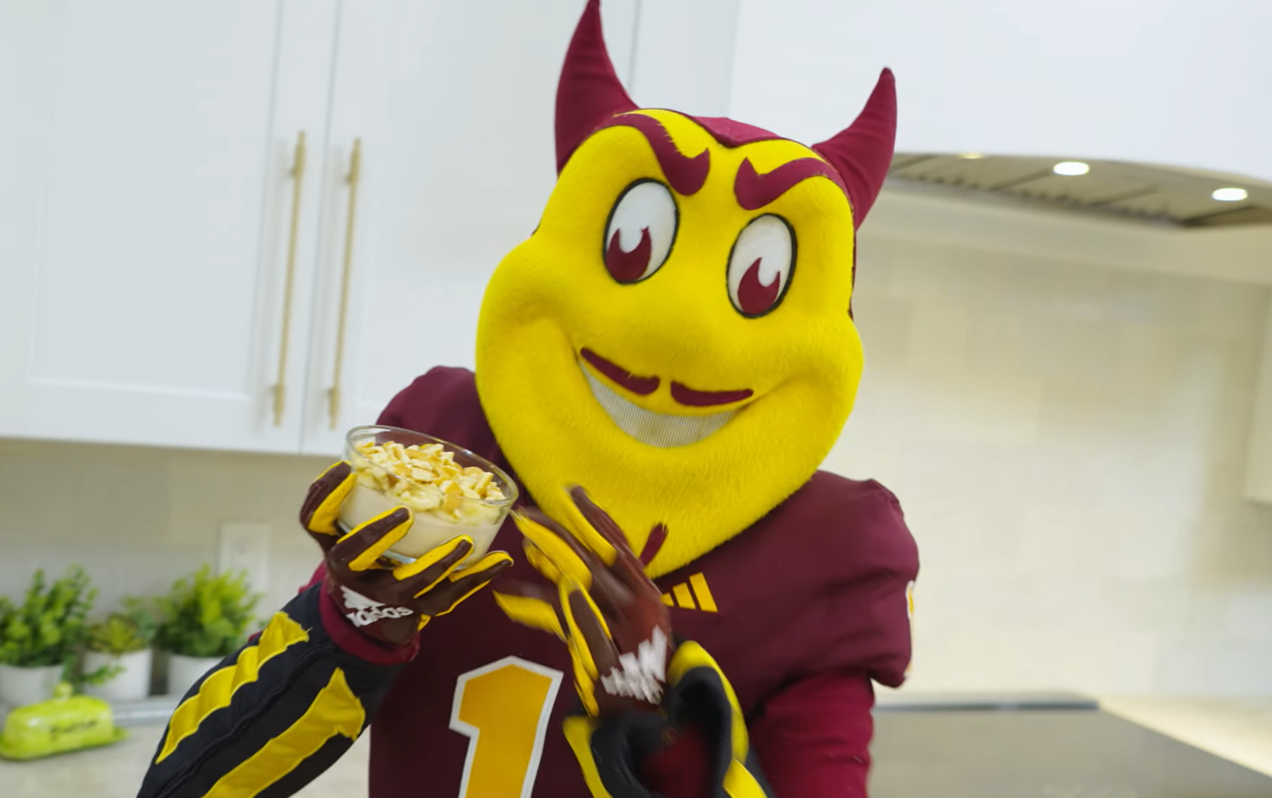 ASU mascot Sparky holding a glass bowl of homemade banana pudding with vanilla wafers crumbled on top